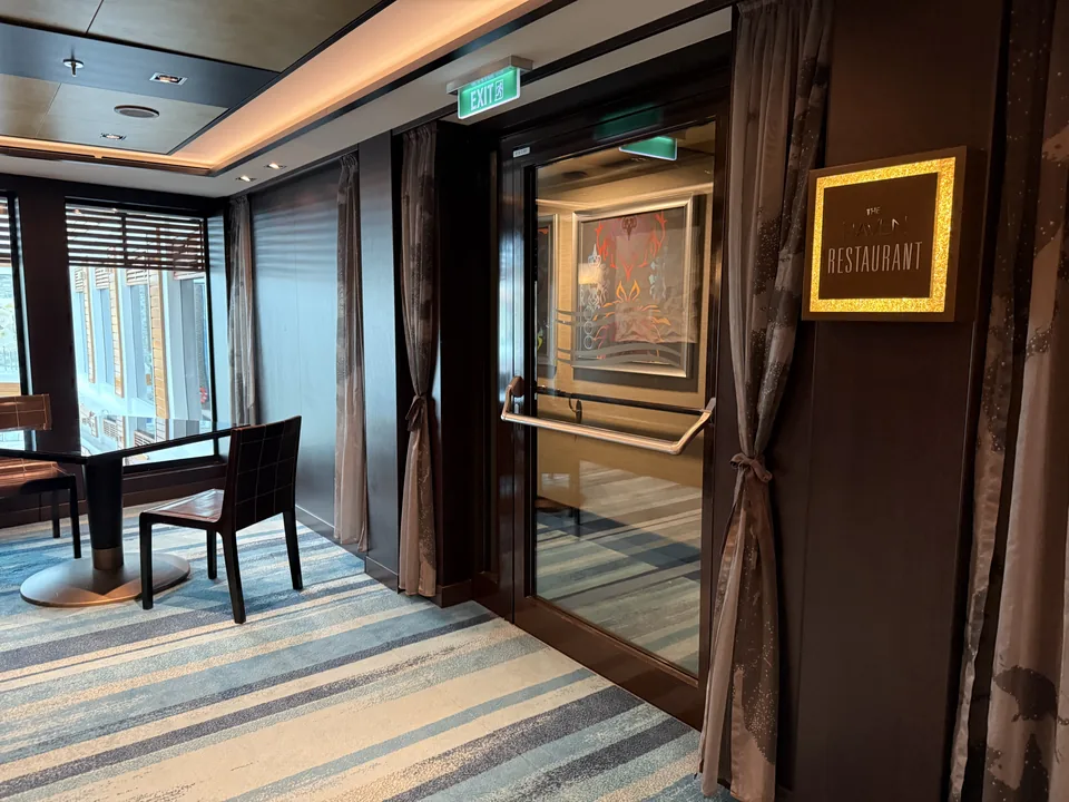 Indgangen til The Haven Restaurant på Norwegian Escape med guldindrammet skilt og glasdør
