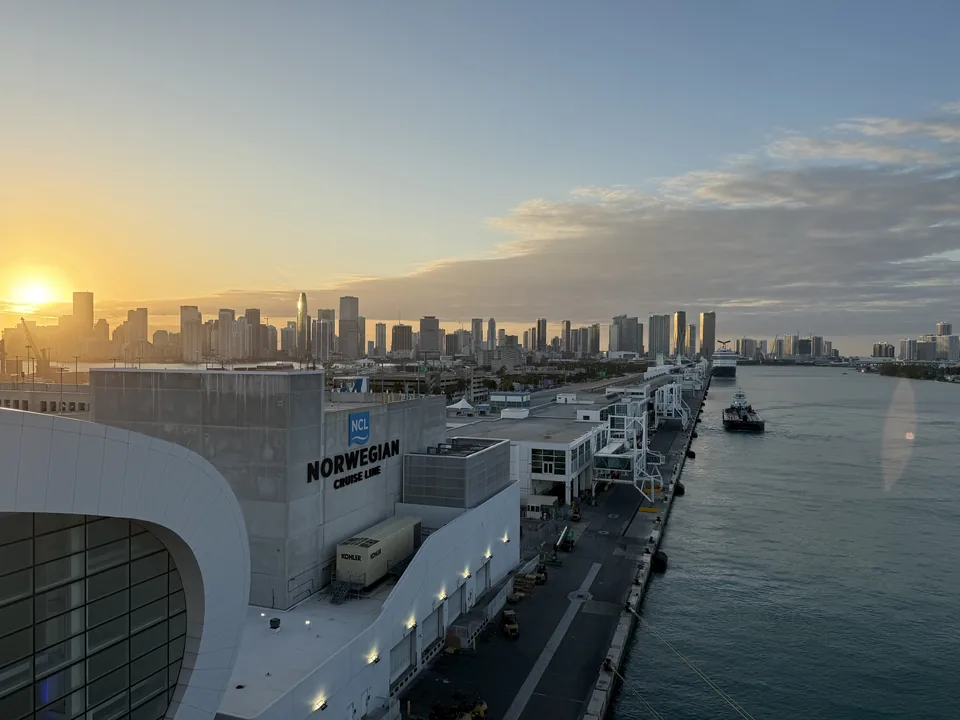 Solnedgang over Miamis skyline og Norwegian-terminalen i PortMiami set fra Norwegian Escape ved sailaway