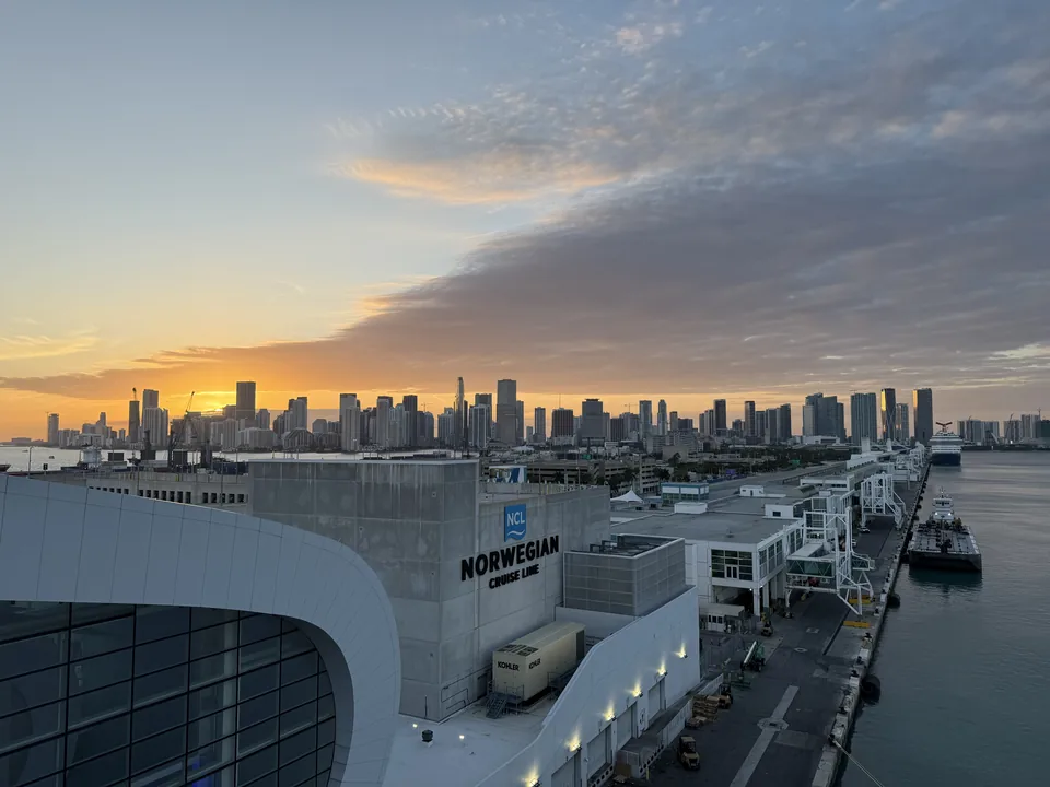 Farverig solnedgang over Miamis skyline og PortMiami set fra Norwegian Escape ved afgang