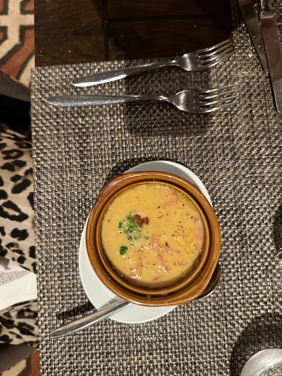 Suppe i brun lerskål set oppefra på et dækket bord på La Cucina på Norwegian Escape