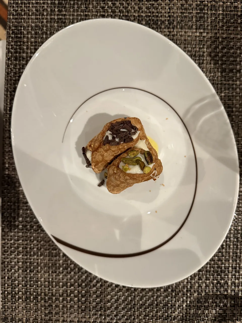 Cannoli med chokolade og pistacie set oppefra i dyb tallerken på La Cucina på Norwegian Escape