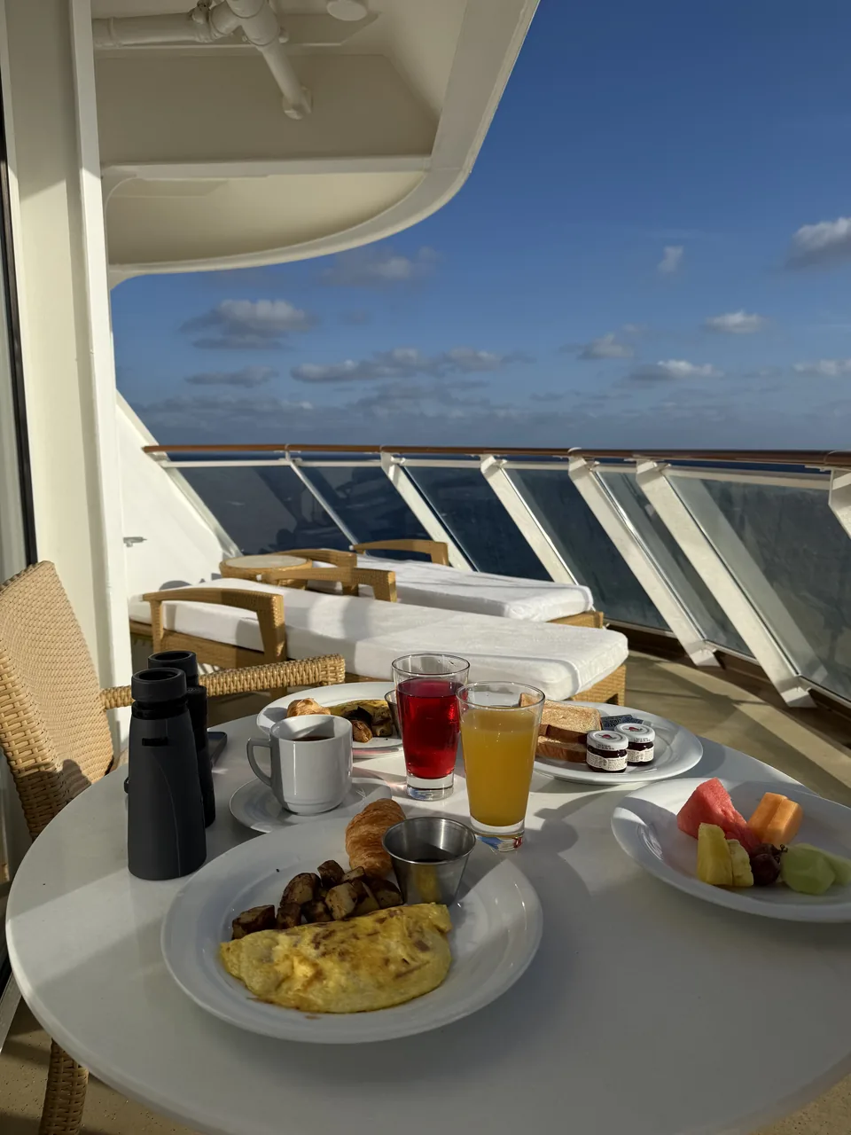 Morgenmad med omelet, frugt og juice på terrassen til suite 13906 med havudsigt på Norwegian Escape