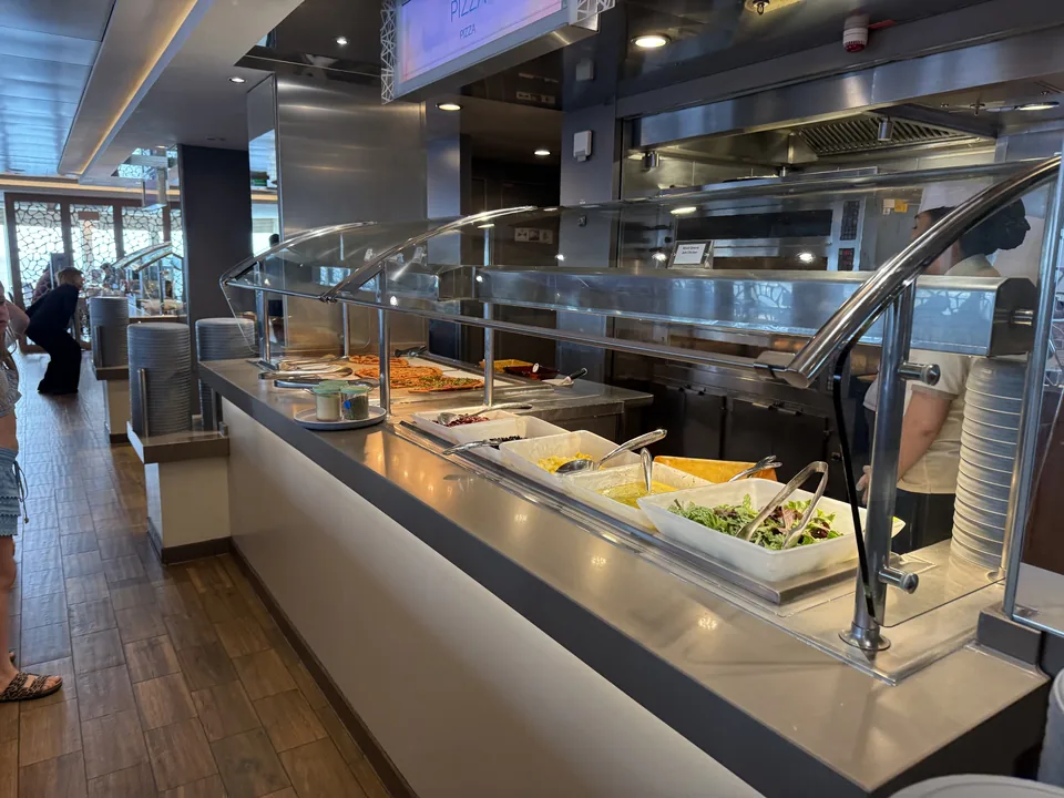 Pizza, salater og dressinger på buffetstationen i Garden Café på Norwegian Escape