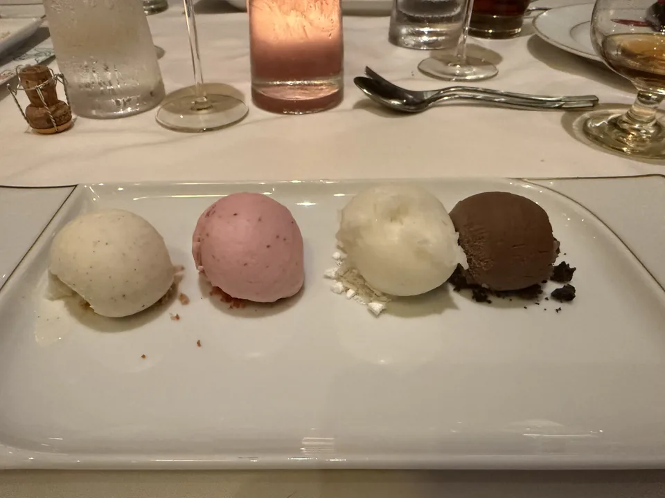 Fire kugler is og sorbet på et aflangt fad som dessert på Le Bistro på Norwegian Escape