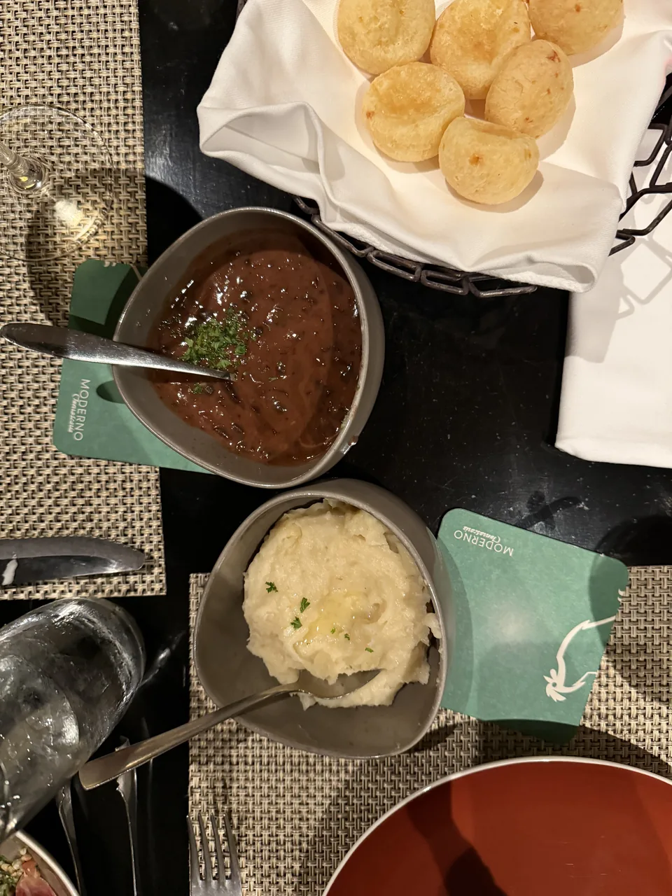 Pão de queijo, kartoffelmos og mørk sauce på bordet hos Moderno Churrascaria på Norwegian Escape