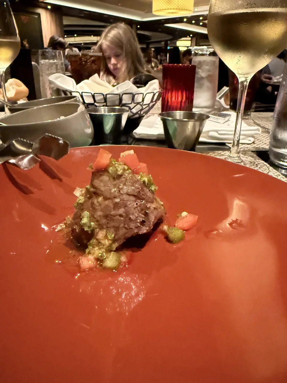 Grillet kød med grøn urtesauce og tomatsalsa på rød tallerken hos Moderno Churrascaria på Norwegian Escape