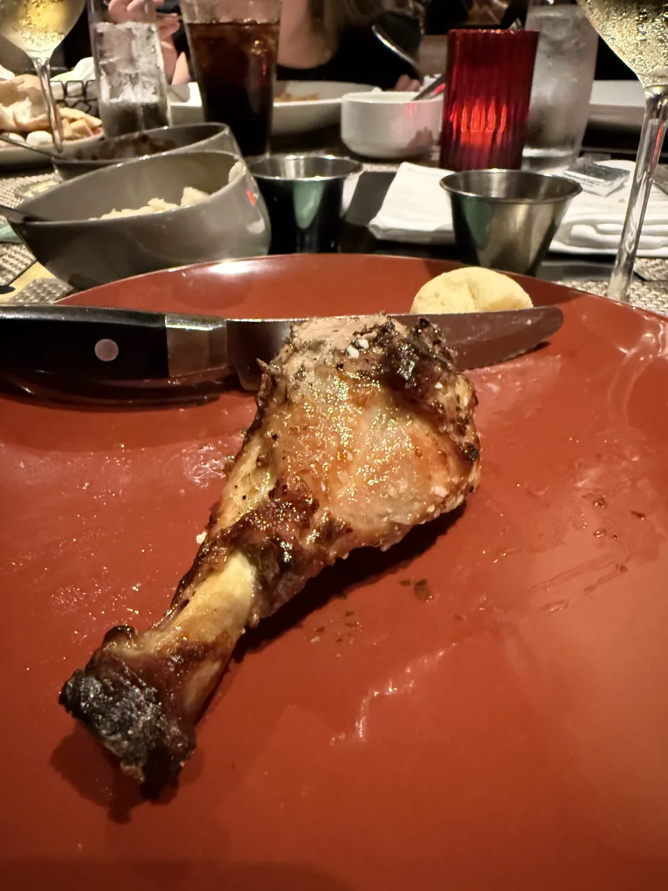 Grillet kyllingeunderlår fra spyddet på rød tallerken hos Moderno Churrascaria på Norwegian Escape