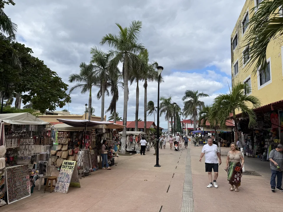 Gågade med høje palmer, souvenirboder og henna-skilt i centrum af Cozumel i Mexico