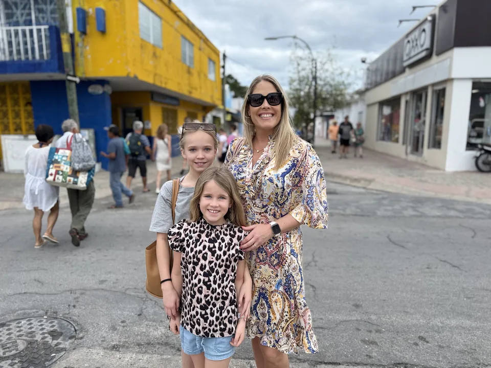 Dianna og døtrene på en gade med gule og blå huse i centrum af Cozumel i Mexico