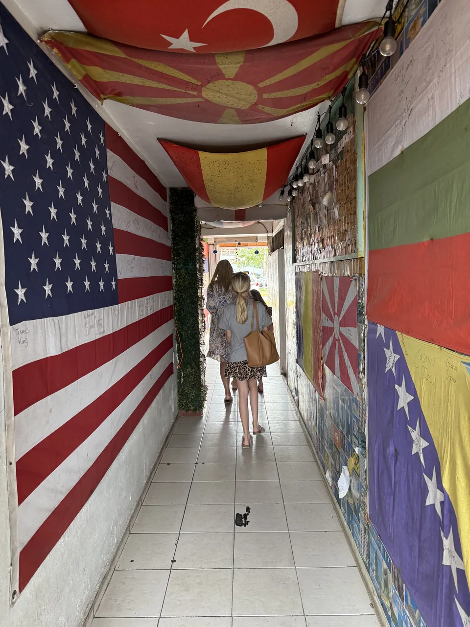 Smal gang med store nationalflag på vægge og loft ved crew-baren på Cozumel