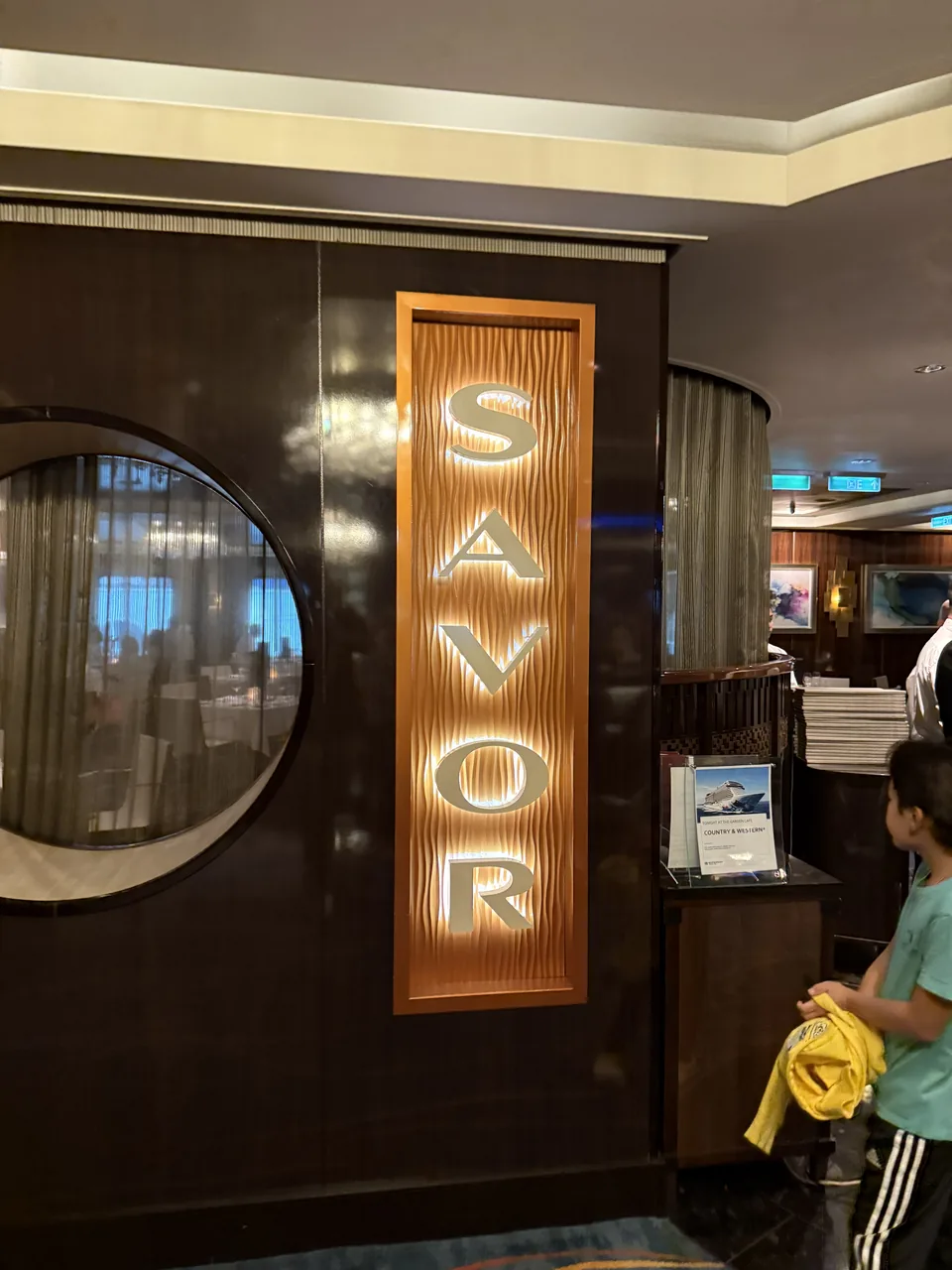 Det oplyste Savor-skilt ved indgangen til hovedrestauranten på Norwegian Escape