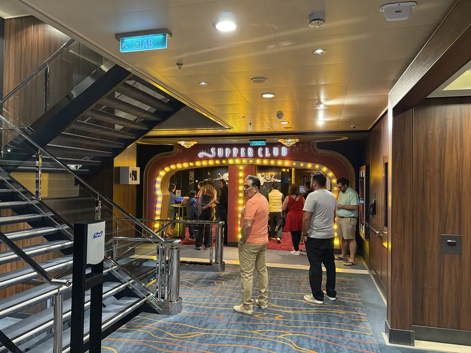 Indgangen til Supper Club på Norwegian Escape med oplyst portal, hvor gæster venter før showet