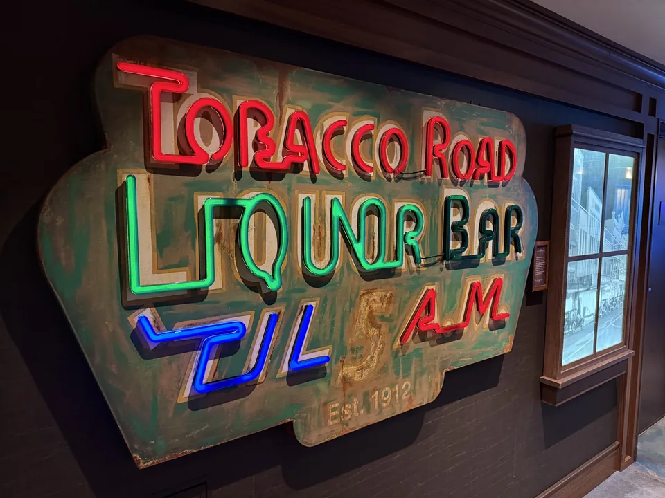 Neonskiltet ved Tobacco Road Liquor Bar om bord på Norwegian Escape i rødt, grønt og blåt lys