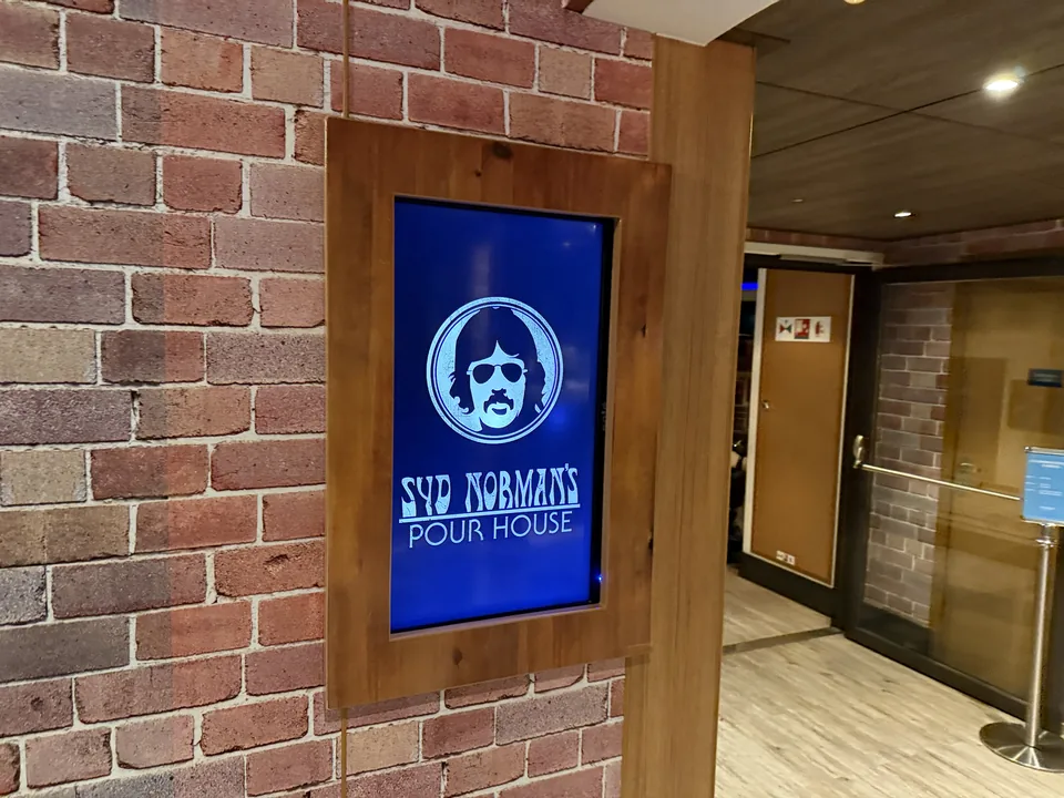 Skærmskilt ved indgangen til Syd Norman's Pour House, rockbaren om bord på Norwegian Escape