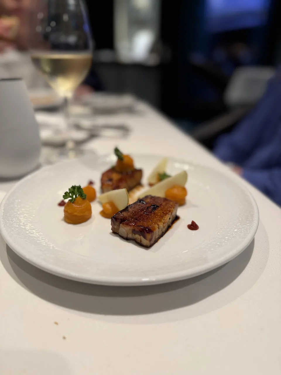 Glaseret svinekød med orange puré og friske frugtskiver i Restaurant Haven på Norwegian Escape