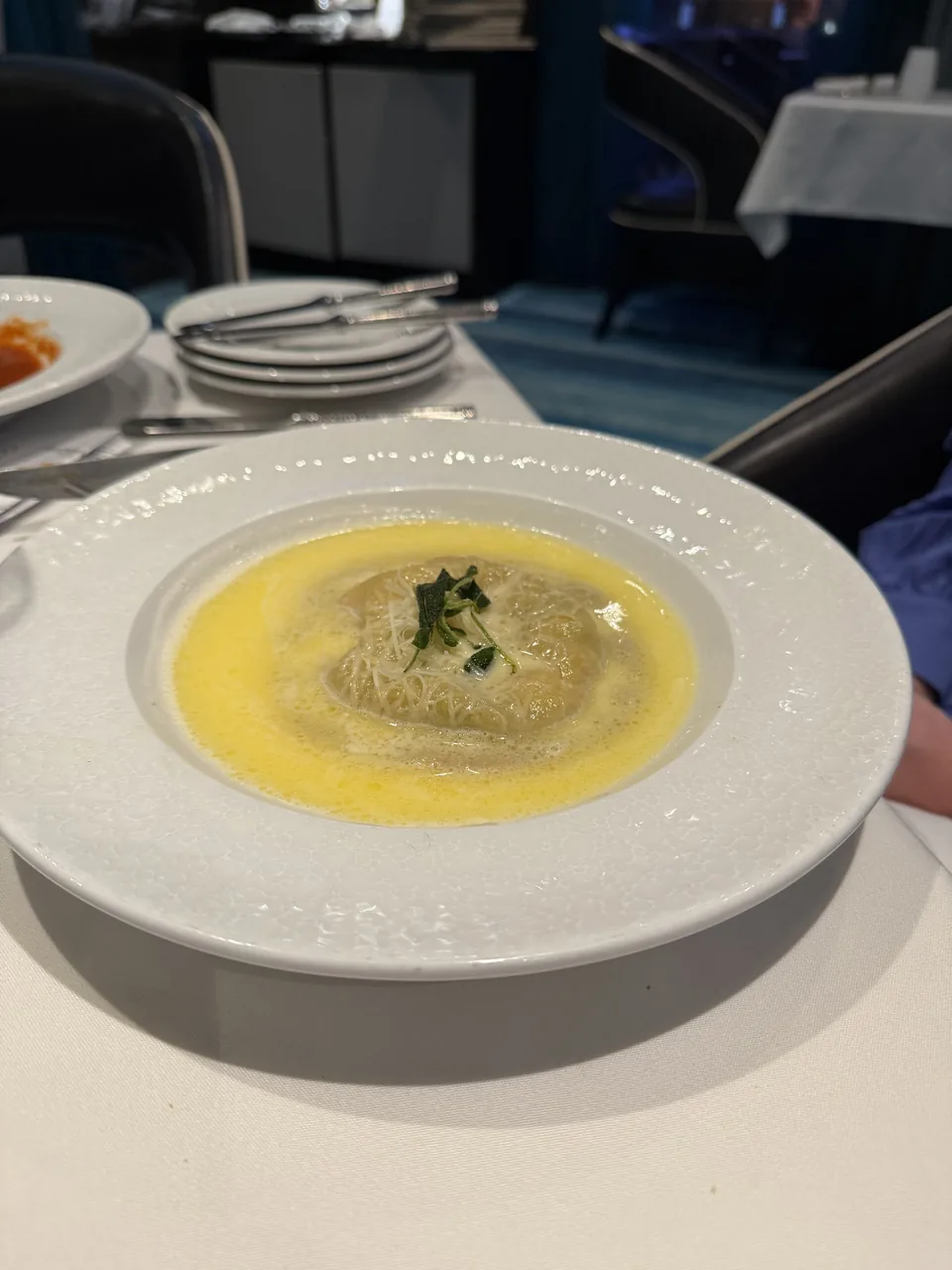 Stor ravioli i gylden smørsauce med revet ost i Restaurant Haven på Norwegian Escape