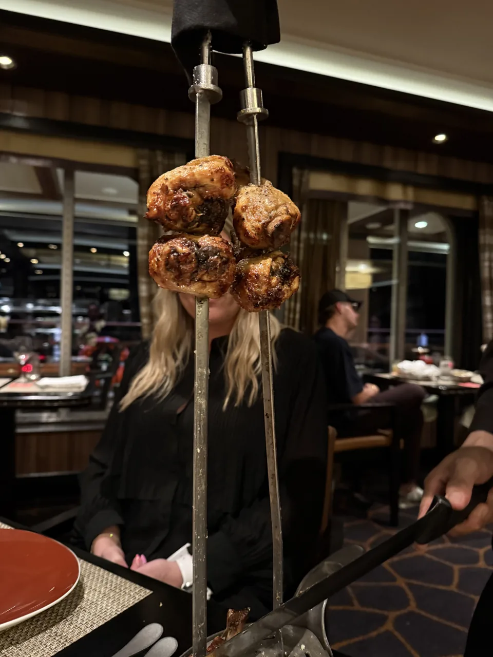 Grillet kød på to spyd præsenteret ved bordet på Moderno Churrascaria på Norwegian Escape