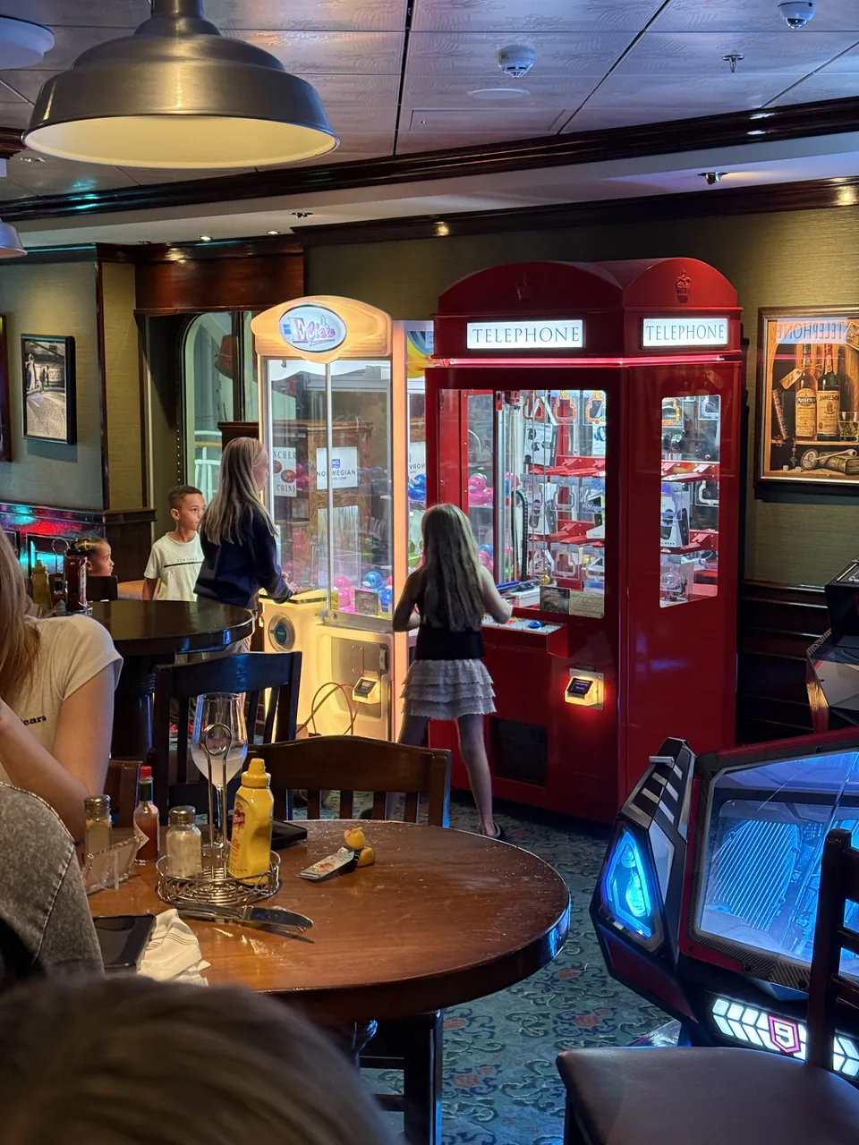 Pub om bord på Norwegian Escape med griberautomat formet som en rød London-telefonboks