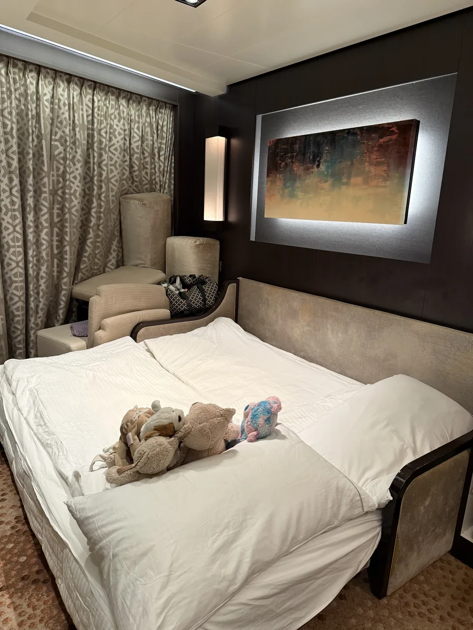 Opredt sovesofa med tøjdyr i stuen i suite 13906 i The Haven på Norwegian Escape
