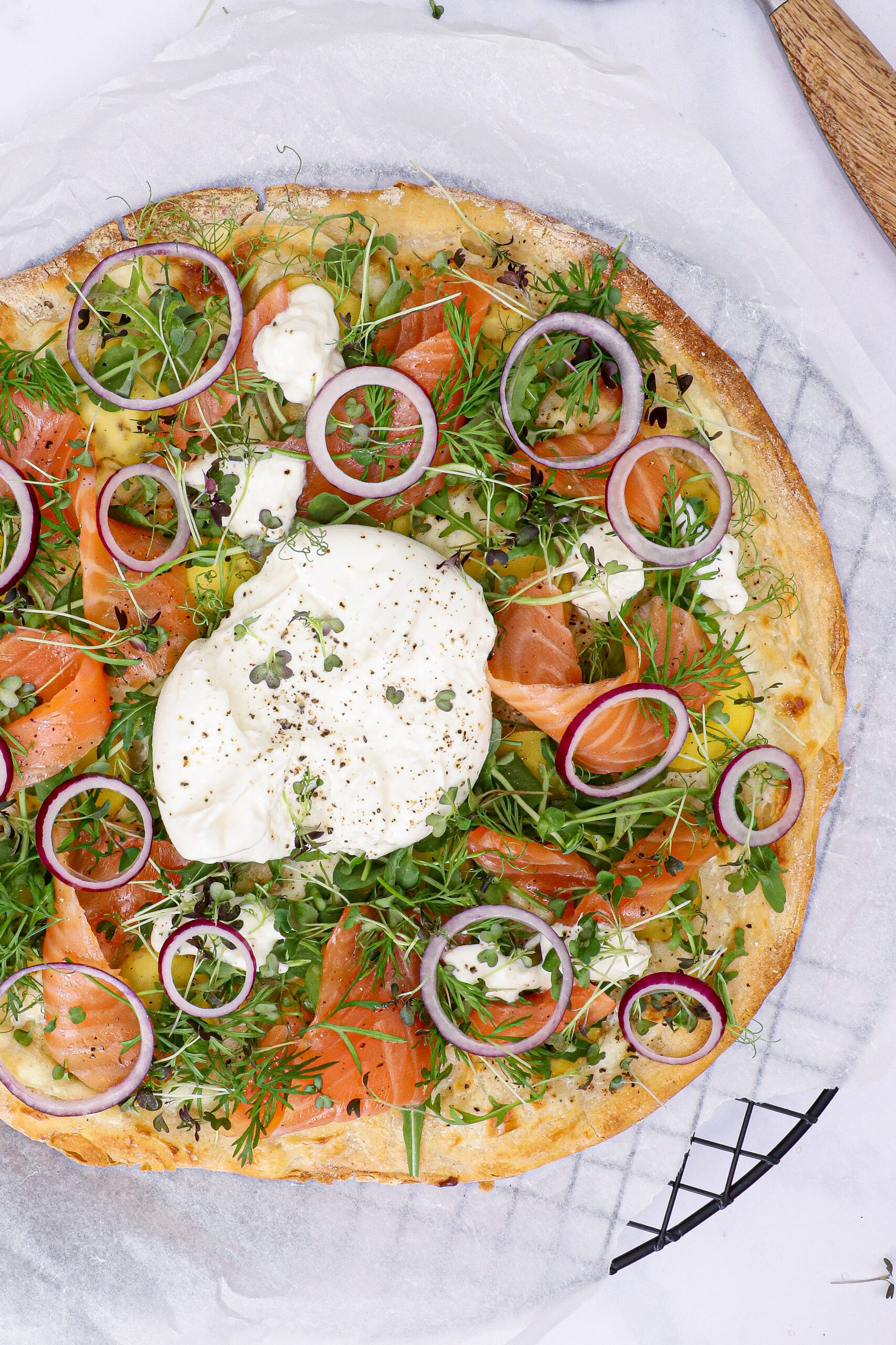 Hvid pizza med røget laks, kartofler, urter og burrata