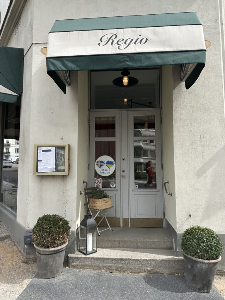 Regio Helsingborg indgang til italiensk restaurant med markise og planter.