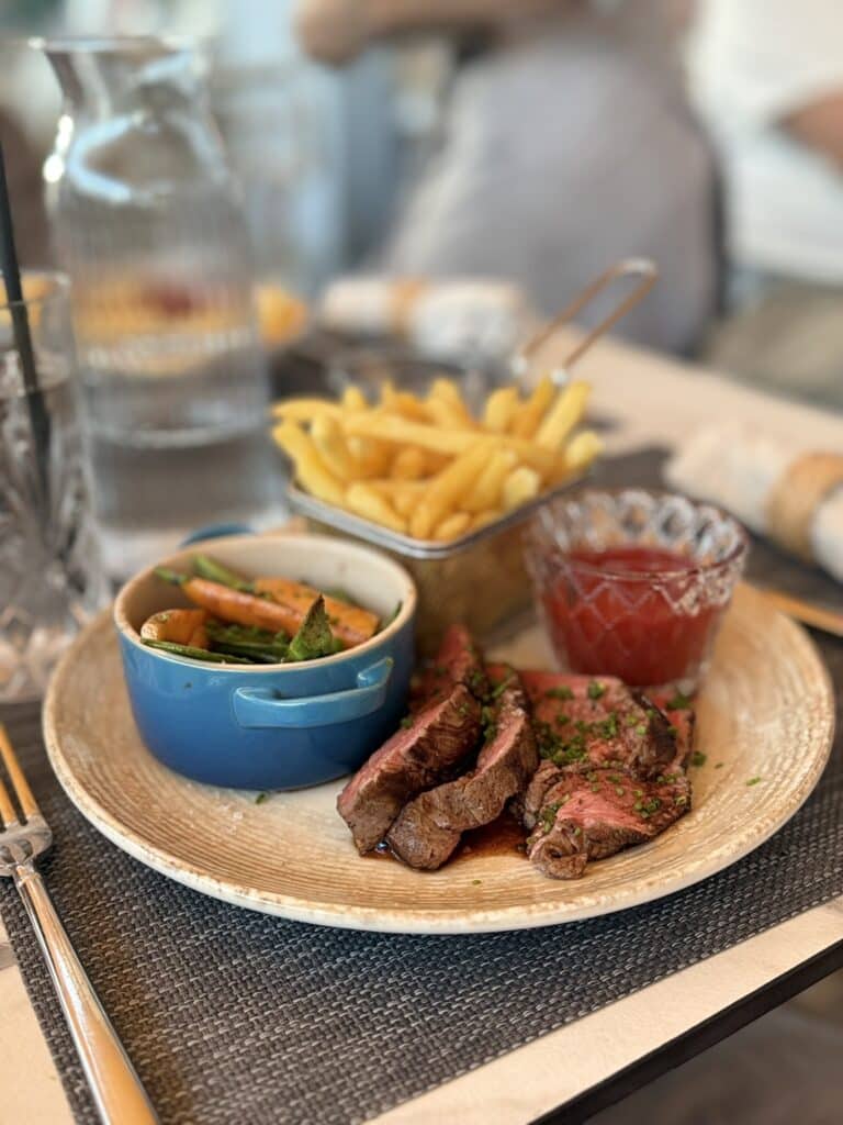 Skiveskåret oksekød med pommes frites, grøntsager og ketchup