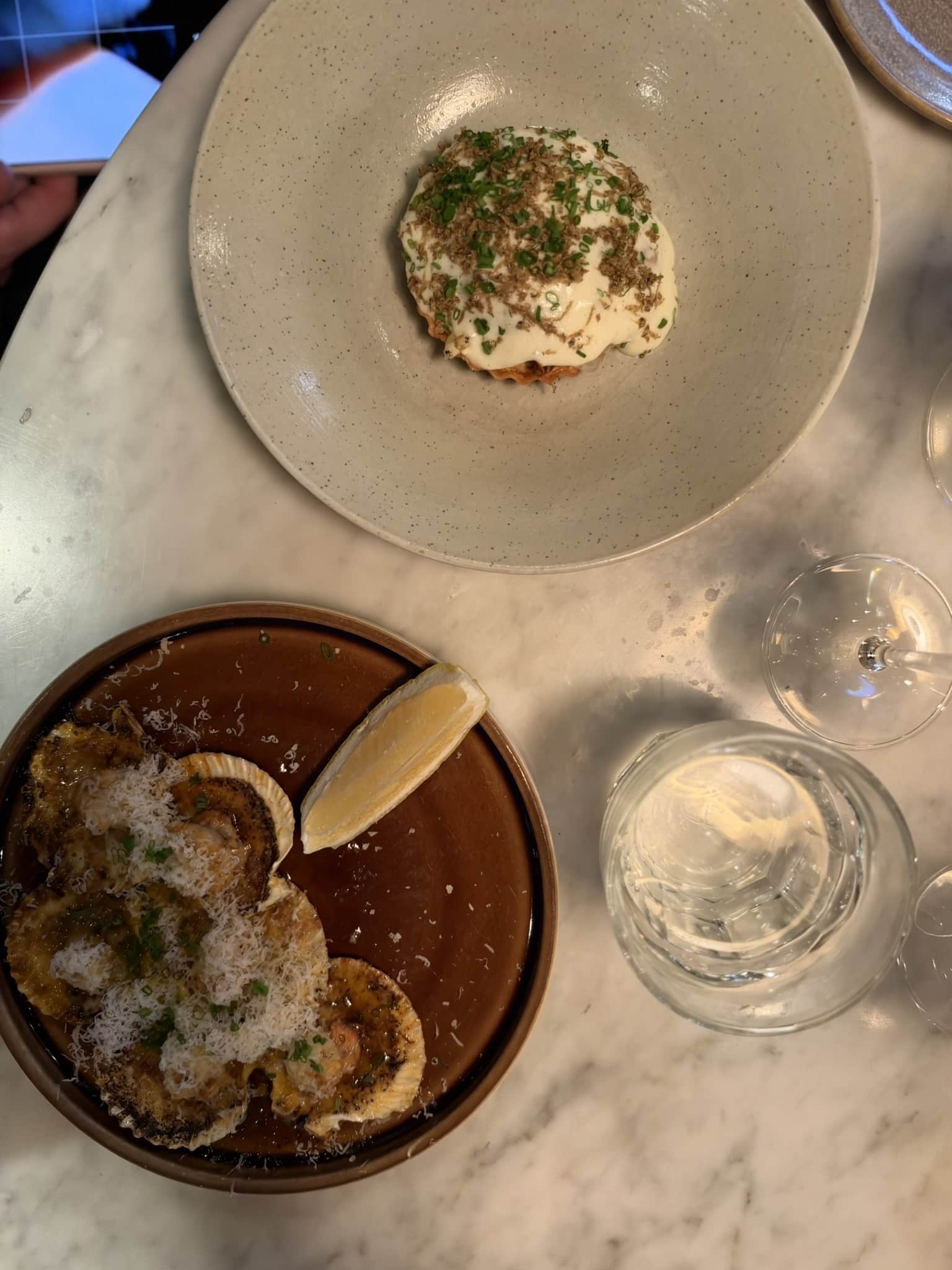 Gratinerede muslinger i skal med revet ost og citron samt tærte med creme og purløg