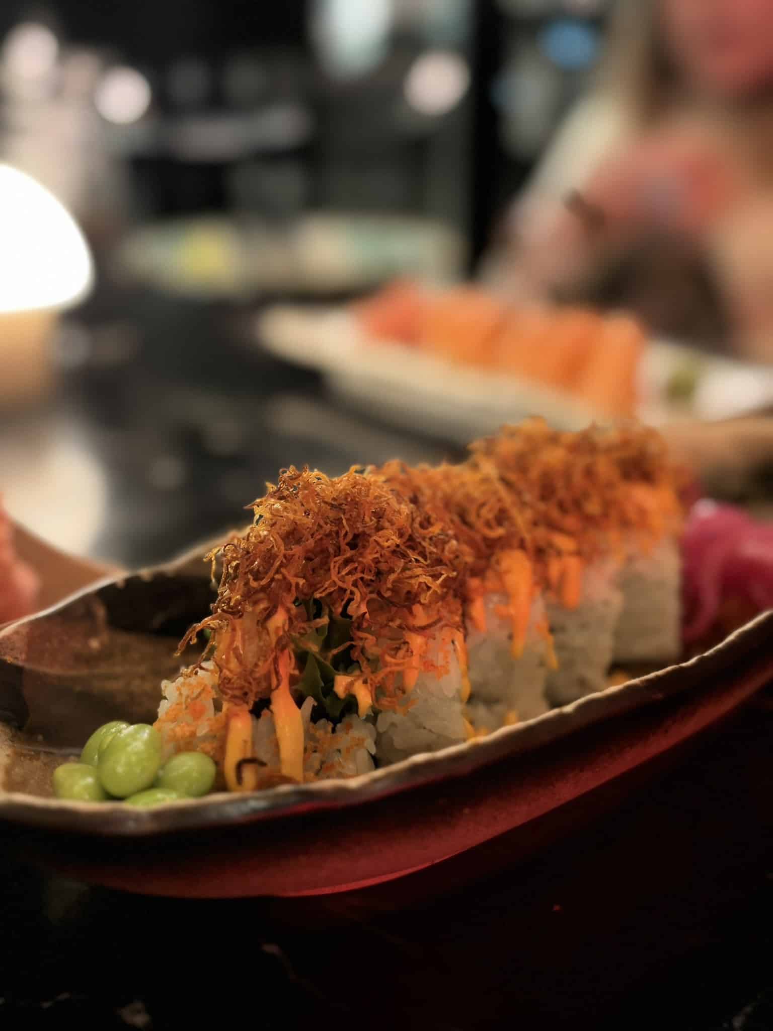 Sushiruller toppet med sprøde løg og spicy mayo, edamame ved siden