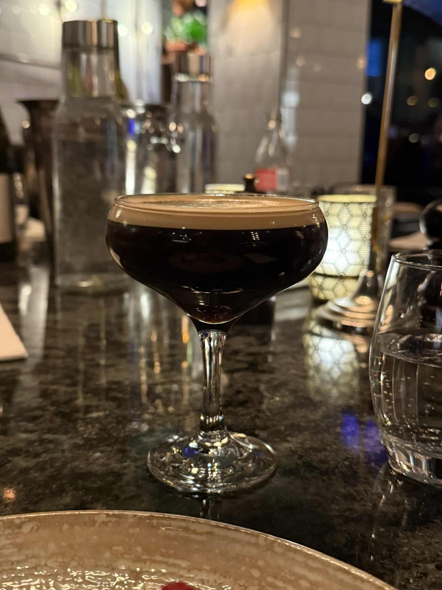 Espresso martini i coupeglas på mørk stenbardisk