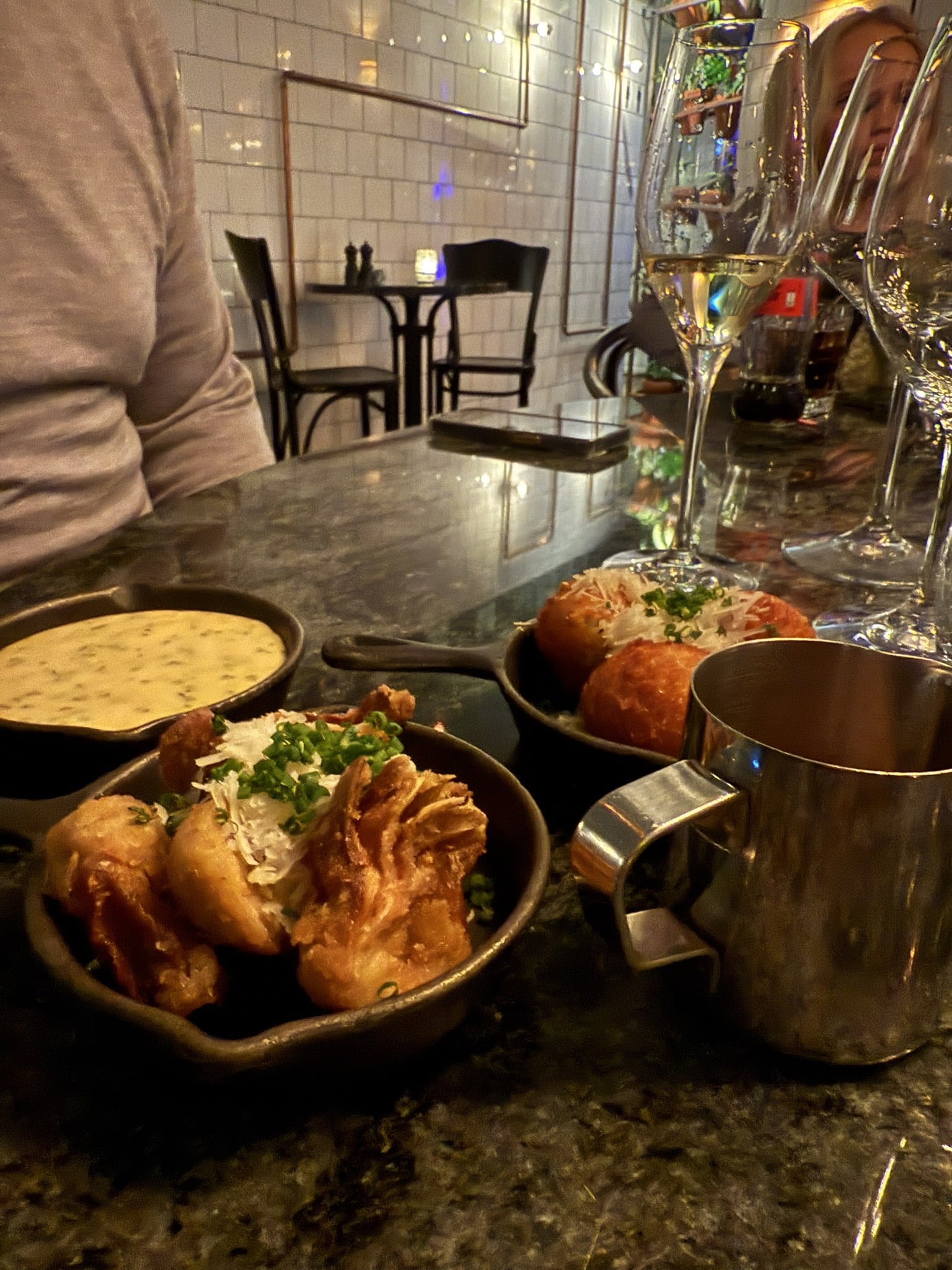 Små støbejernspander med bearnaise, friturestegte artiskokker og kroketter på bardisk.