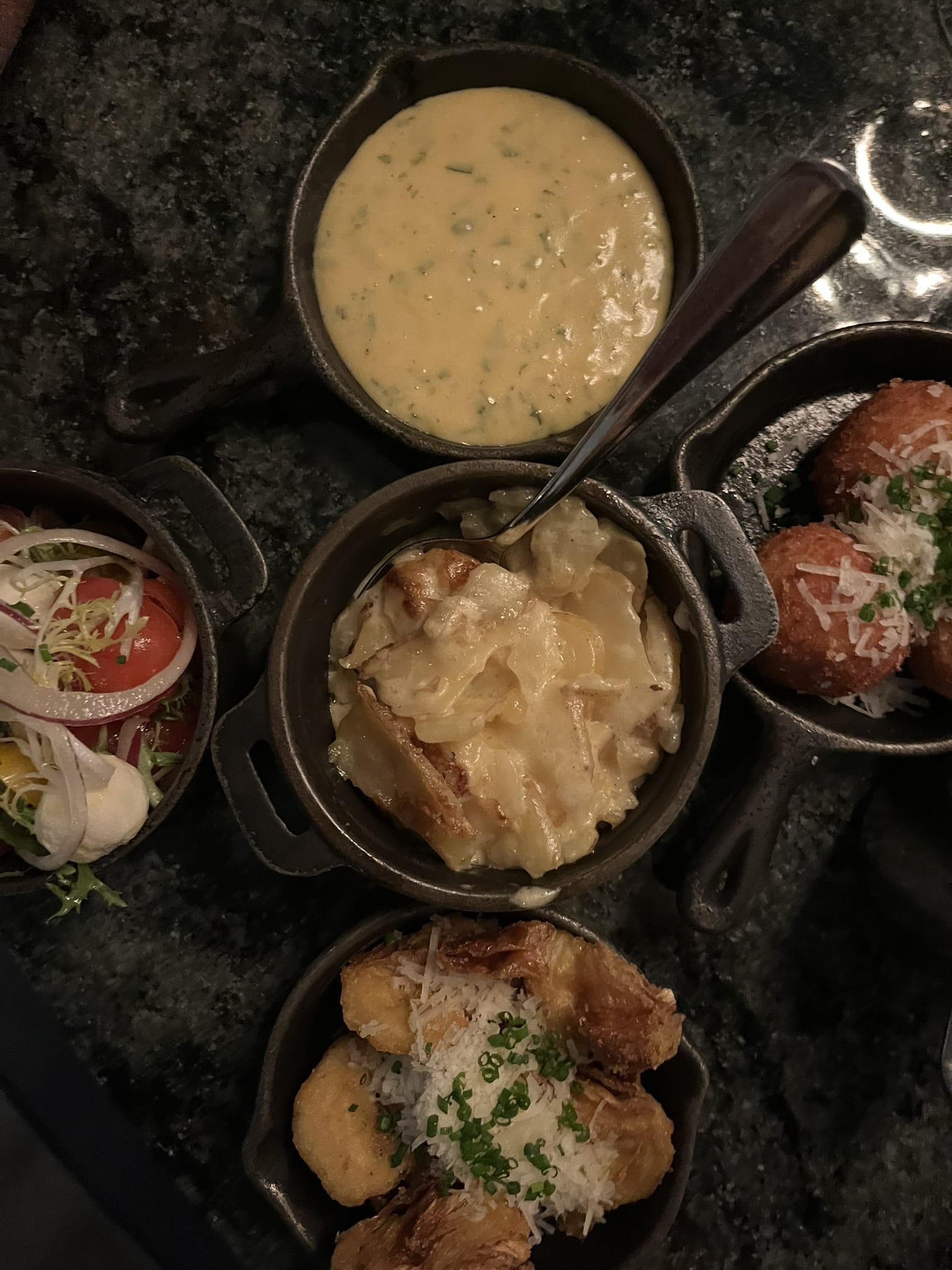 Tilbehør i støbejern: bearnaise, kartoffelgratin, kroketter, tomatsalat og friturestegte artiskokker.
