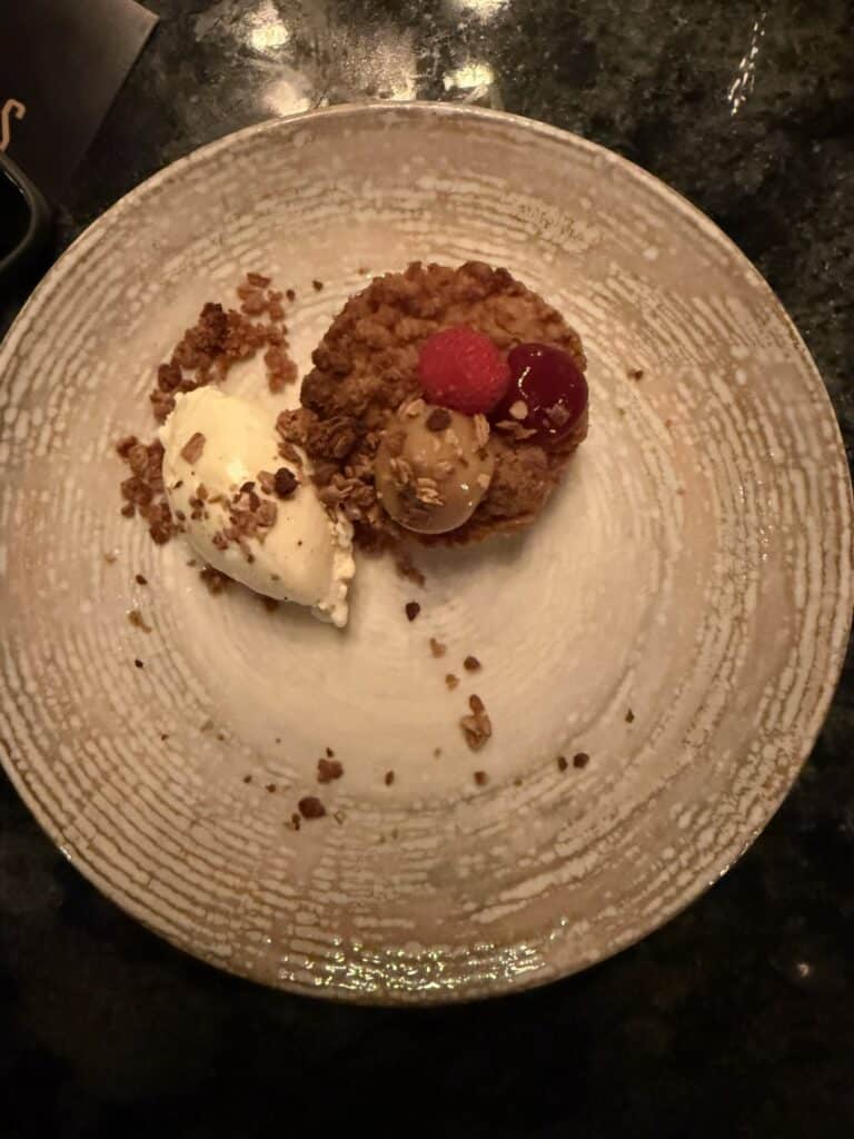 Crumble-tærte med hindbær, kirsebær, granola og en kugle is